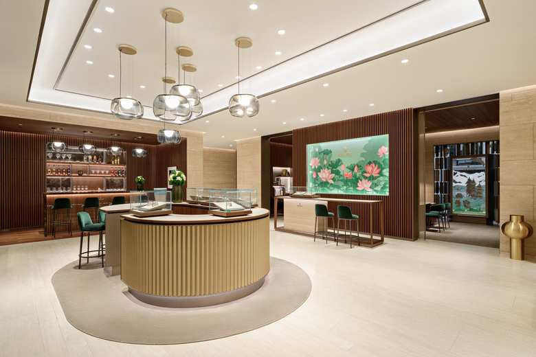 Interior of DAFC Rolex boutique in Vietnam with elegant glass display cases, wooden slatted walls, crystal pendant lights, and luxury watches showcased under warm lighting.