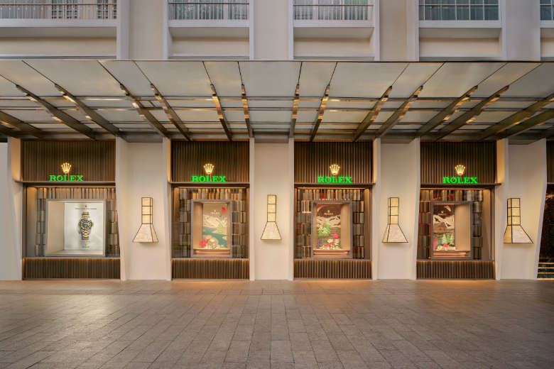 DAFC Rolex boutique exterior with four illuminated display windows showcasing luxury watches in a modern, elegant setting.