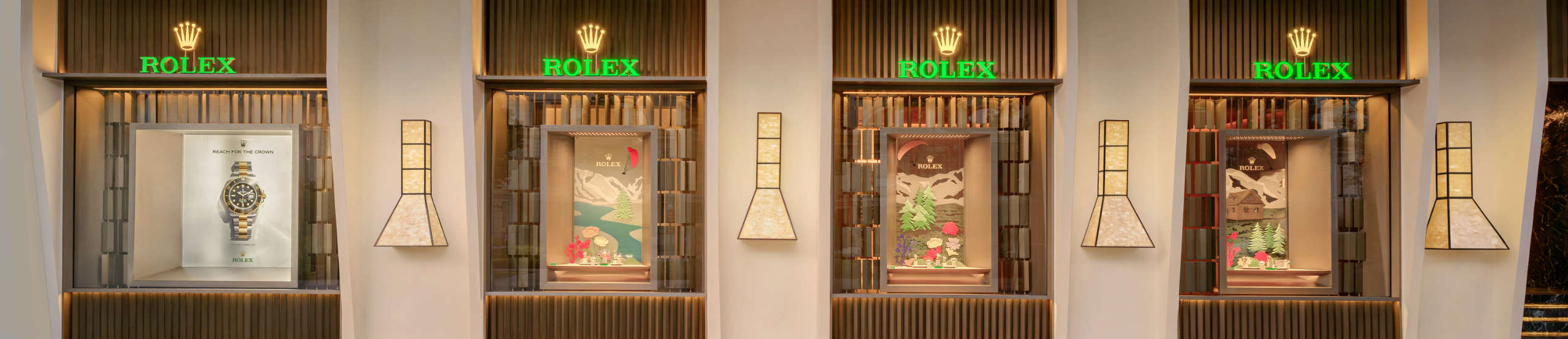 DAFC Rolex boutique exterior with four illuminated display windows showcasing luxury watches in a modern, elegant setting.